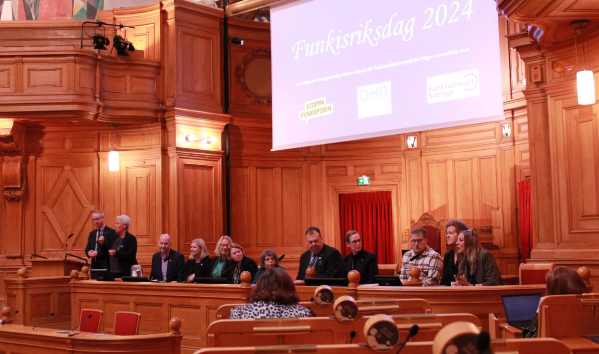 Representanter från alla Riksdagens samtliga partier på Funktisriksdagen, stående bredvid varandra i Förstakammarsalen.